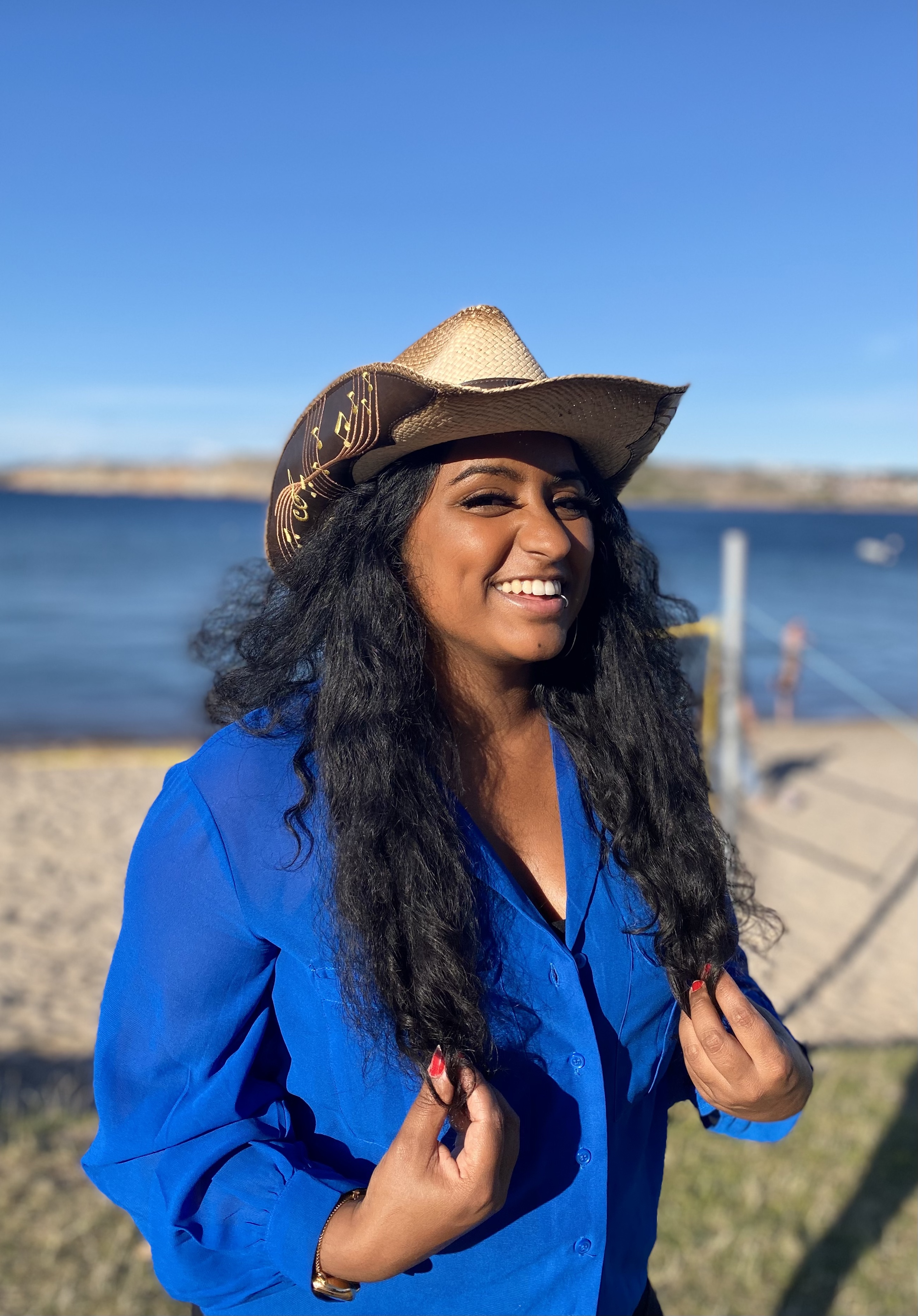 Bild på Amelia skogfält med en cowboy hatt framför havet och blå himmel